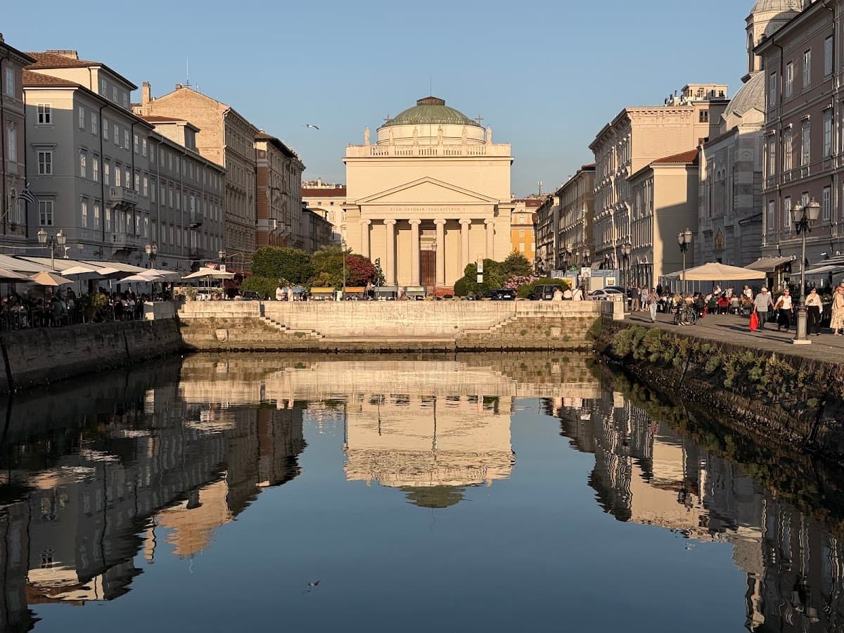 Neoclassical church and historic buildings reflected in canal water in European city center