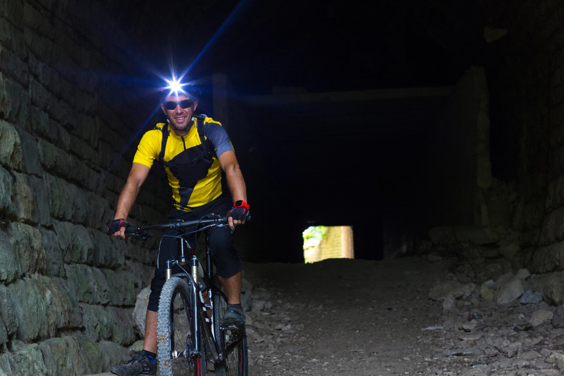Croatien, Istria, Parenzana Biketrail, Mountainbiker wearing headlamp in tunnel